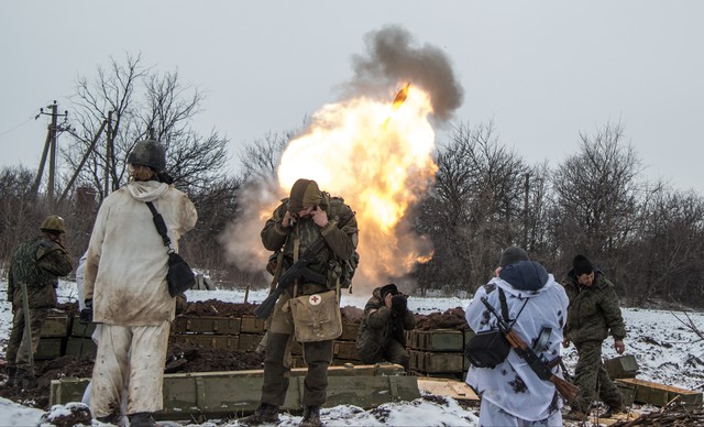 Ukrajinští separatisté si zakrývají uši při střelbě minometu na ukrajinskou armádu.