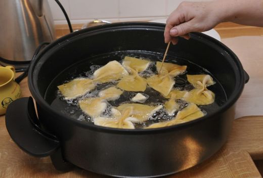 Trojhranné koláčky pojmenované Hamanovy uši (na snímku při smažení).