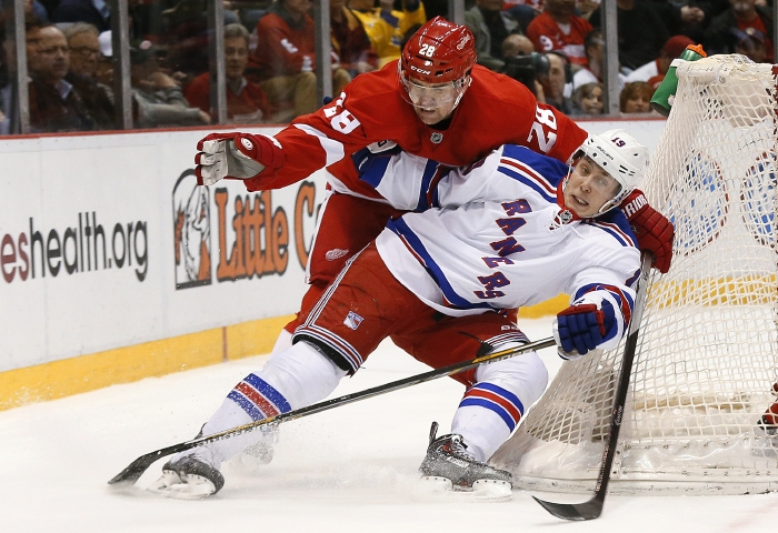 Marek Židlický (v červeném dresu) v utkání NHL proti New York Rangers. 