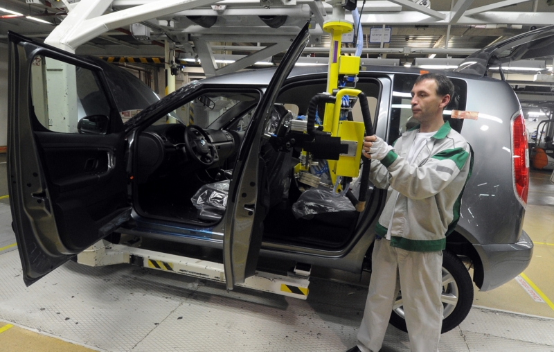 Pracovník při montáži automobilu. Pracovník při montáži automobilu.