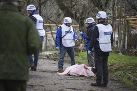 Pozorovatelé OBSE stojí nad tělem mrtvého ukrajinského vojáka u obce Šyrokyne.