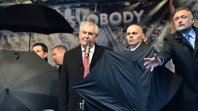 Zemana loni na pražském Albertově museli bodyguardi chránit deštníky.