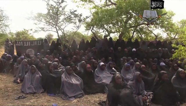 Na videozáznamu unesené nigerijské dívky - asi 130 dívek oblečených v typických muslimských šatech, takzvaném hidžábu. Obličeje mají odhalené. Dívky sedí na zemi kdesi v přírodě a modlí se verše z koránu.