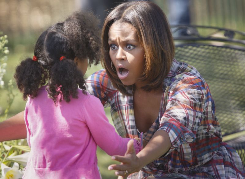 Michelle Obama při objímání dívenky na zahradě Bílého domu.