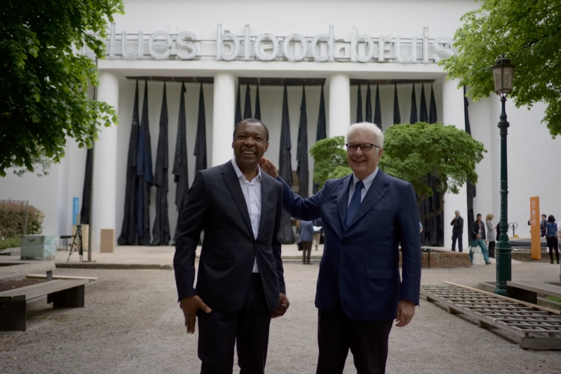 Okwui Enwezor (vlevo), kurátor 56. ročníku benátského bienále, s prezidentem bienále Paolem Barattem. Okwui Enwezor (vlevo), kurátor 56. ročníku benátského bienále, s prezidentem bienále Paolem Barattem.