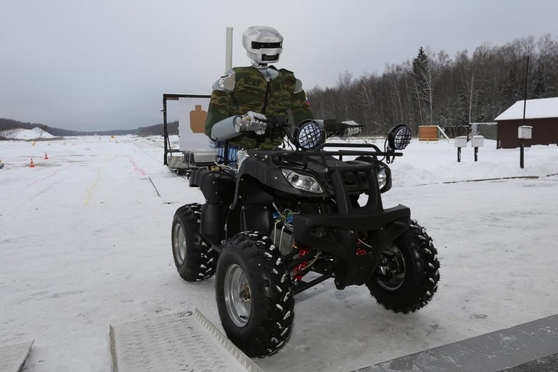 Bojový robot jede na čtyřkolce a střílí.