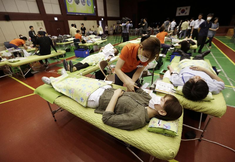Jihokorejské zdravotnice neustále pracují s rouškami, aby snížili riziko nákazy.