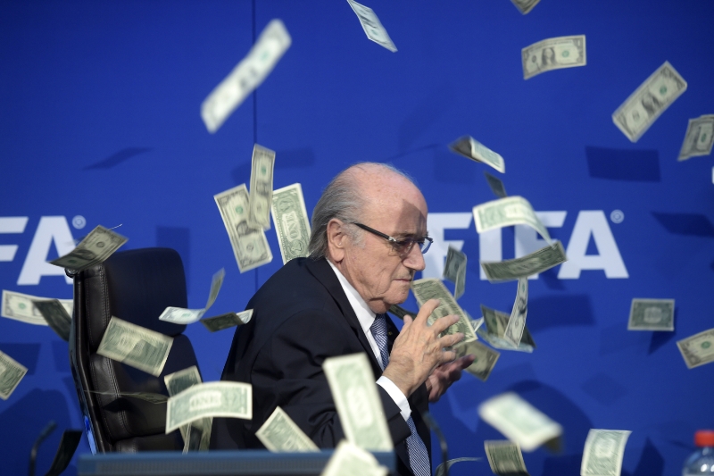 Sepp Blatter s bankovkami nad hlavou.