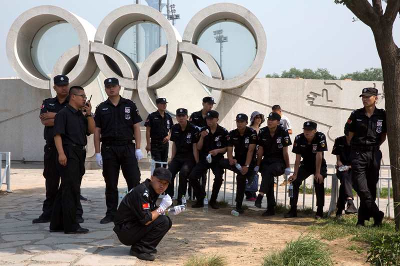 Čínští policisté před olympijskými kruhy.