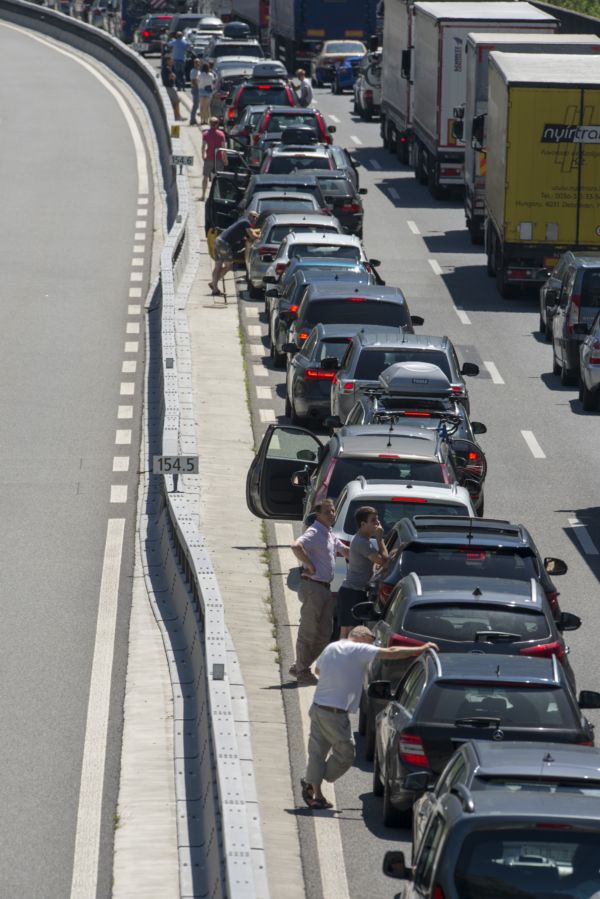 Lidé postávají vedle aut v zácpě na rakouské dálnici (ilustrační foto).