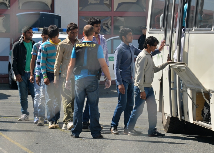 Na dálnici D5 na Tachovsku zadržela policie 31. července nákladní auto s běženci. Na snímku nastupují do přistaveného autobusu.