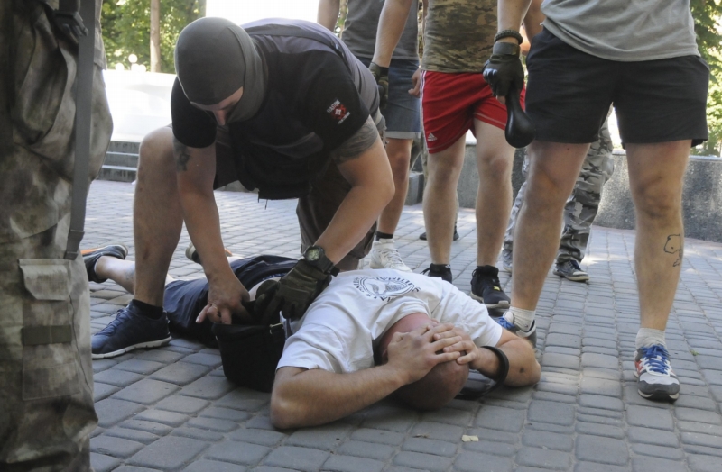 Policista v civilu zatýká proruského aktivistu po vlně násilí Charkově.
