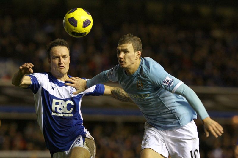 Edin Džeko v akci (bleděmodrý dres), hlídá ho bývalý český reprezentant Martin Jiránek. 