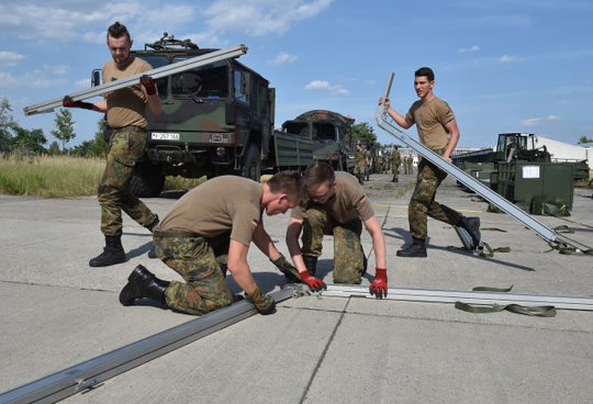 Vojáci bundeswehru budují nouzové přístřešky pro migranty.