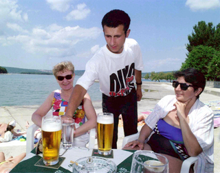 Chorvatský junák servíruje českým turistkám u moře pivko.