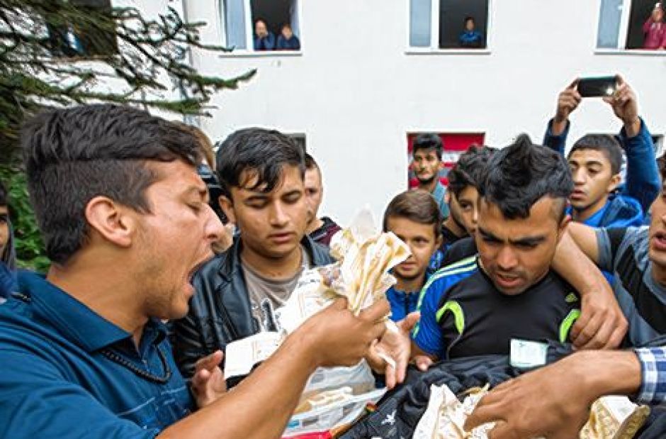 Muslimští migranti v Suhlu ukazují roztrhaný korán.