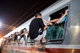 Uprchlík se v Chorvatsku snaží dostat do autobusu.