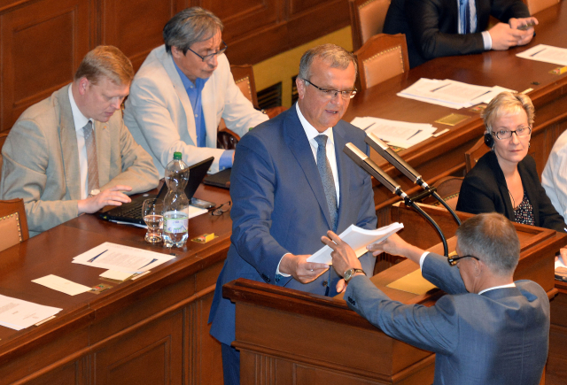 Miroslav Kalousek při projevu. Před řečnickým pultem stojí Andrej Babiš.