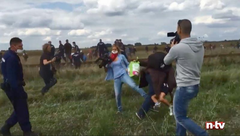Reportérka Petra Lászlóová podrazila nohy uprchlíkovi s dítětem v náručí. Reportérka Petra Lászlóová podrazila nohy uprchlíkovi s dítětem v náručí.