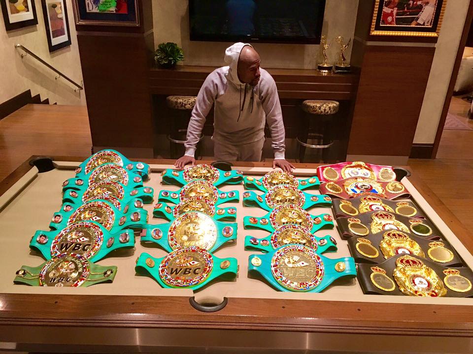 Floyd Mayweather se svou sbírkou šampionských pásů.