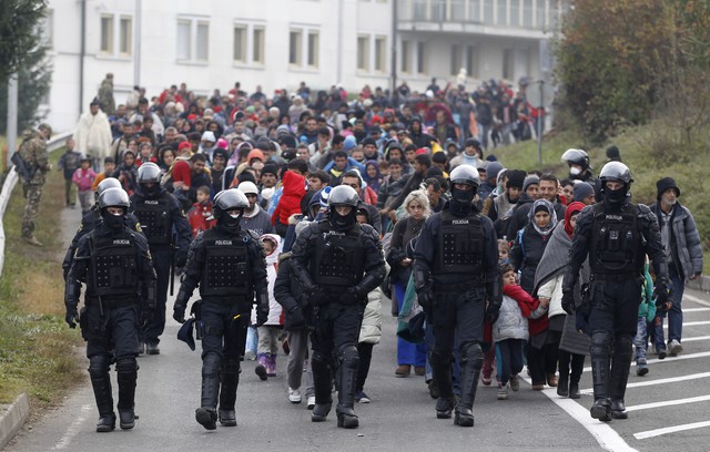 Zástup uprchlíků opouští v doprovodu policistů tábor Šentilj ve Slovinsku a míří do Rakouska. 