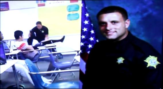 Vpravo na fotografii je policista Ben Fields. Fotografie také autenticky zachycuje spoutání studentky.