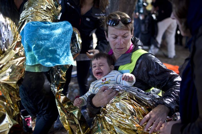 Dobrovolnice pečuje o dítě uprchlíků na řeckém ostrově Lesbos.