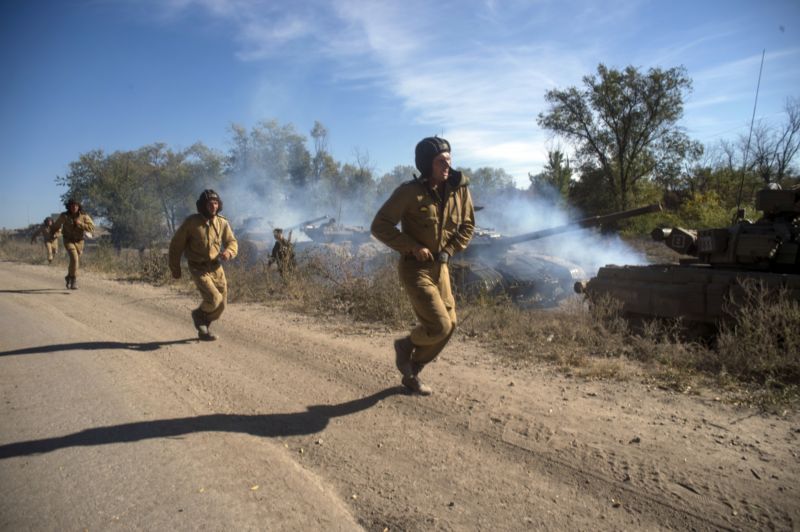 Pro-ruští povstalci běží podél kolony tanků připravujících se na stažení těžkých zbraní z přední linie, východní Ukrajina. Pro-ruští povstalci běží podél kolony tanků připravujících se na stažení těžkých zbraní z přední linie, východní Ukrajina.