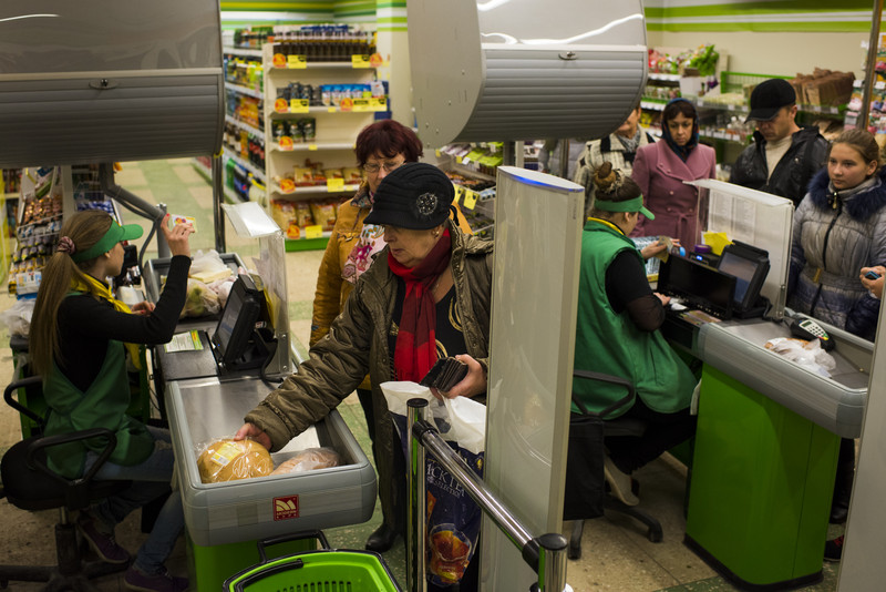 Lidé směňují poukázky za jídlo v supermarketu na východě Ukrajiny.