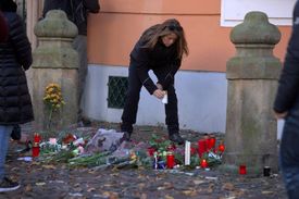 Lidé zapalují svíčky před francouzskou ambasádou.