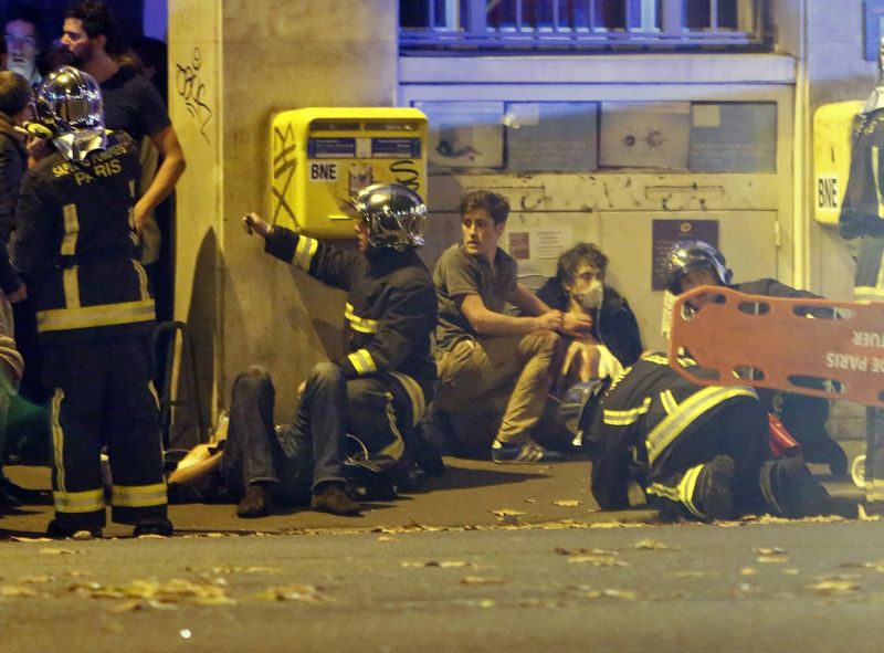 Záchranáři pomáhají zraněným před koncertní síní Bataclan.