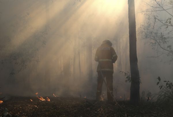 Australský hasič v souboji s lesním požárem.
