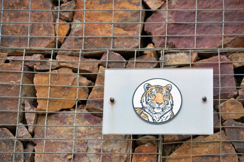 V zoo visí už jen cedule zakazující fotografování s bleskem, obrázek hlavy tygra a vyobrazení čápa, jak kráčí rákosím.