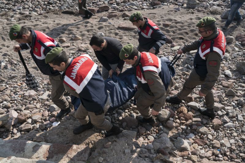 Příslušníci turecké vojenské policie odklízejí mrtvá těla utonulých migrantů z pláže u Egejského moře poblíž tureckého města Ayvacik.