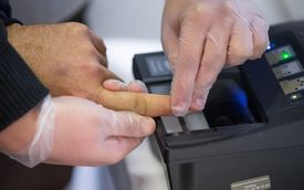 Snímání otisků prstů běžence na centrálním registračním zařízení v Herfordu v Německu.