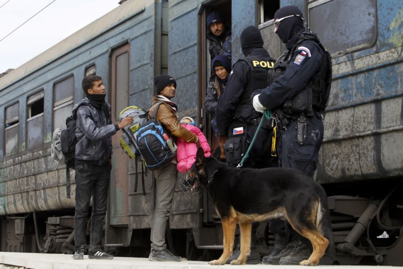 Uprchlíci nastupují do vlaku směřujícího do Srbska, zatímco policisté České republiky udržují pořádek na platformě v tranzitním centru pro uprchlíky v blízkosti jižního makedonského města Gevgelija. Uprchlíci nastupují do vlaku směřujícího do Srbska, zatímco policisté České republiky udržují pořádek na platformě v tranzitním centru pro uprchlíky v blízkosti jižního makedonského města Gevgelija.