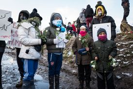 Obyvatelé uprchlického tábora u města Calais přihlížejí jeho likvidaci.