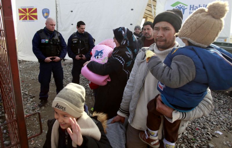 Maďarští policisté kontrolují migranty přicházející z Řecka.