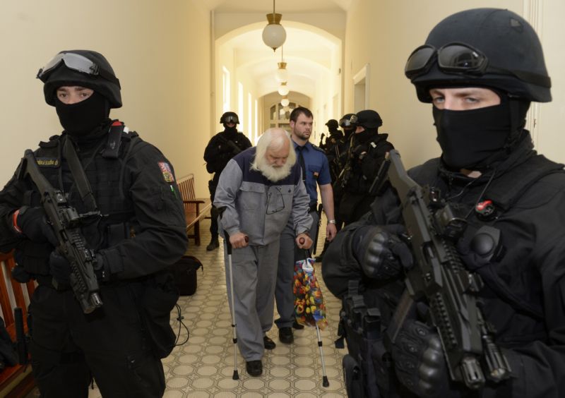 Recidivista Adolf Doležal vedený k soudu.