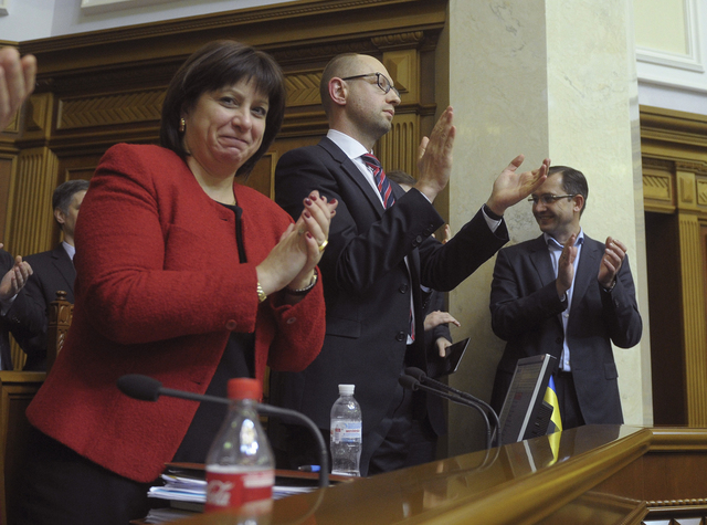 Ukrajinský premiér Arsenij Jaceňuk (uprostřed) a ministryně financí Natalija Jaresková po schválení rozpočtu parlamentem.