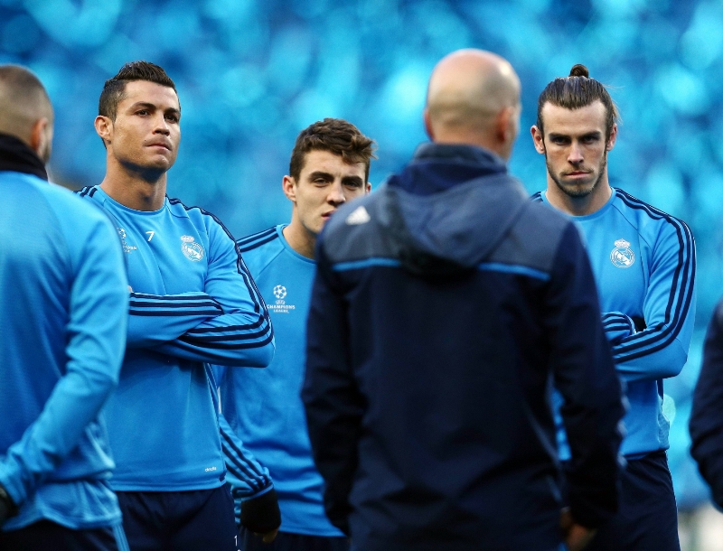 Největší hvězdy Realu Cristiano Ronaldo (vlevo) a Gareth Bale (vpravo) naslouchají trenérovi Zinedinu Zidanovi.