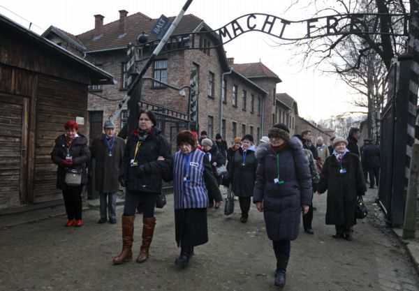 Lidé se vydali na tříkilometrový pochod od brány s nápisem "Arbeit macht frei" (Práce osvobozuje) .