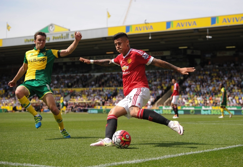 Fotbalista Marcos Rojo z Manchesteru United se snaží odcentrovat míč přes obránce Norwiche.