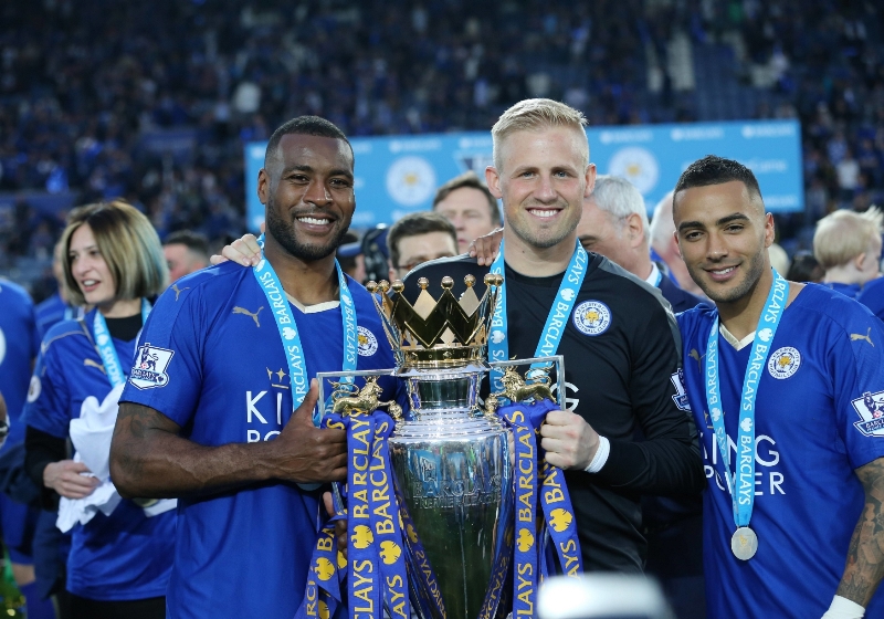 Obránce Leicesteru Danny Simpson (vlevo) s gólmanem Schmeichelem a mistrovskou trofejí. 