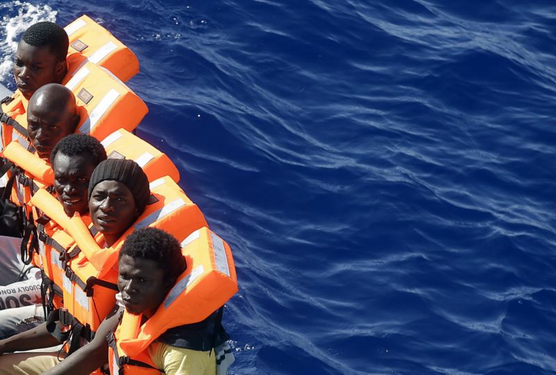 Afričtí migranti plující na člunu ve Středozemním moři u libyjského pobřeží.