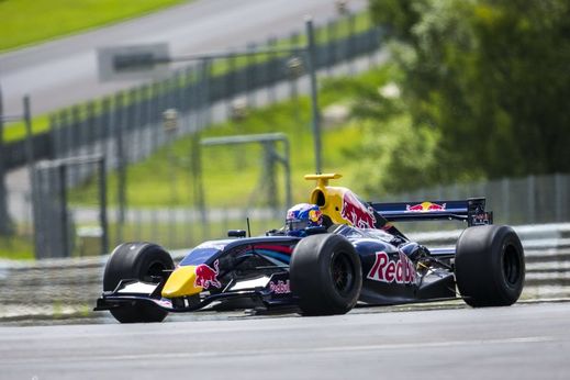 Americká lyžařka Lindsey Vonnová na závodním okruhu s vozem formule 1.