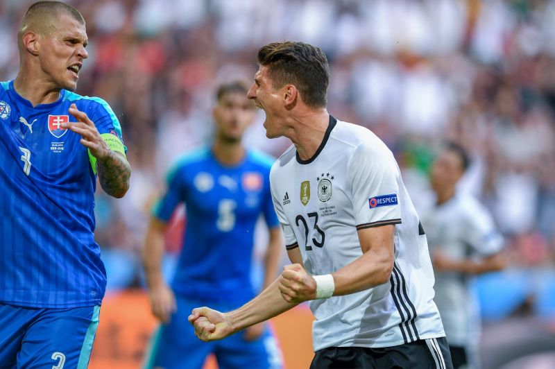 Mario Gomez slaví gól před slovenskými hráči.
