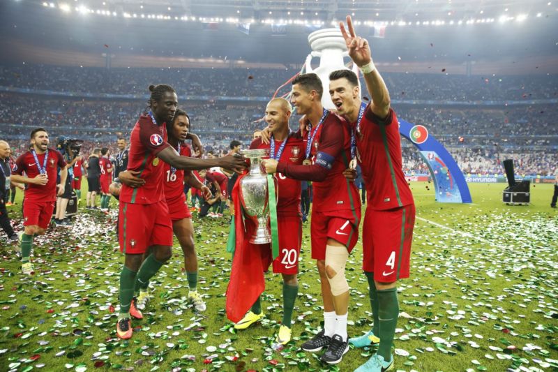 Portugalští hráči slaví s trofejí pro mistry Evropy.