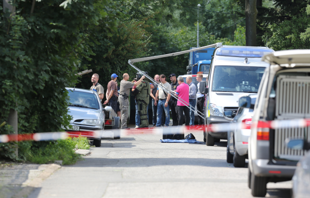 Policejní vyšetřovatelé na místě, kde se střílelo. Policejní vyšetřovatelé na místě, kde se střílelo.