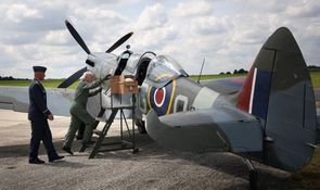 Veterán Emil leze do kokpitu letounu Spitfire.